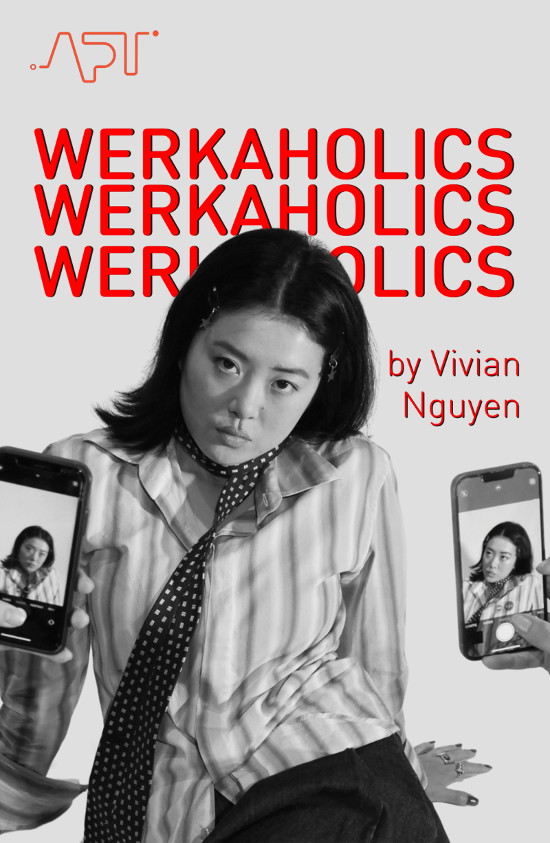 A black and white image of performer Shirong Wu who stares defiantly down the barrel of the camera. From either side of the frame, hands hold up cameras. On the phone screens we can see they are taking photos of Shirong from different angles. Photo is by Lucy Wylie.